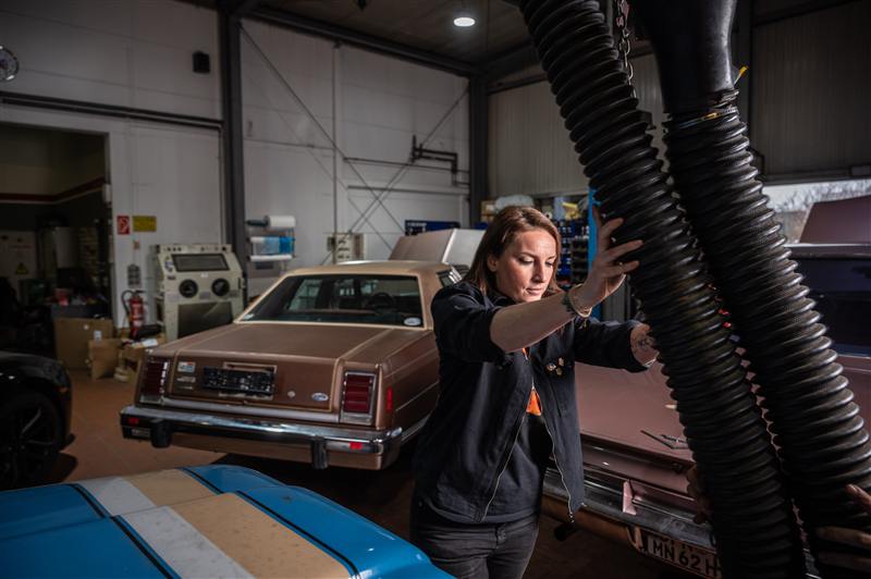 Maja bei der technischen Begutachtung eines Oldtimers in der Werkstatt