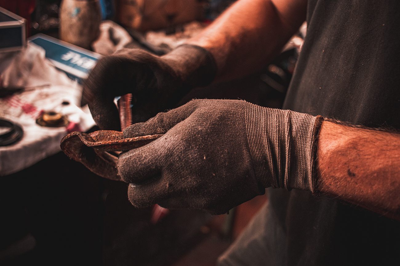 Rost an einer Fahrzeugstrebe in der Hand eines Mechanikers